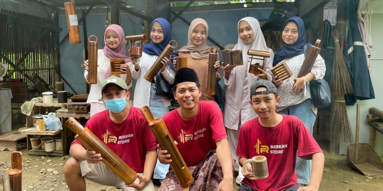 Kang Rosyid, owner Berkah Store Kerajinan Bambu (berkopiyah) berfoto bersama mahasiswi UIN Saizu Purwokerto usai kunjungan kerja di workshop di Kebasen, Banyumas.